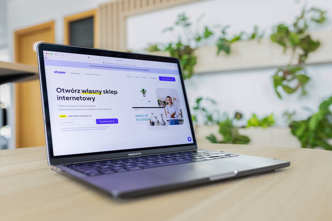 services-01 Close-up of a laptop with an open e-commerce website, surrounded by modern office decor.